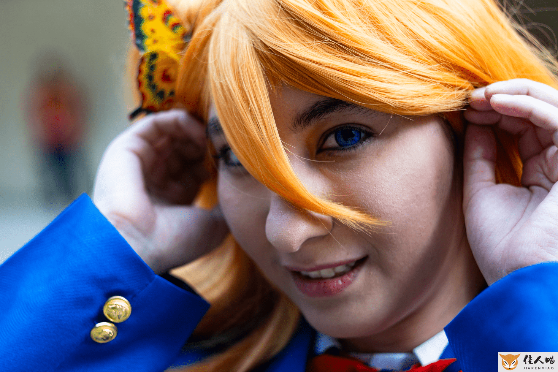 Close-up of a person in colorful cosplay attire with a vivid butterfly accent, smiling outdoors.