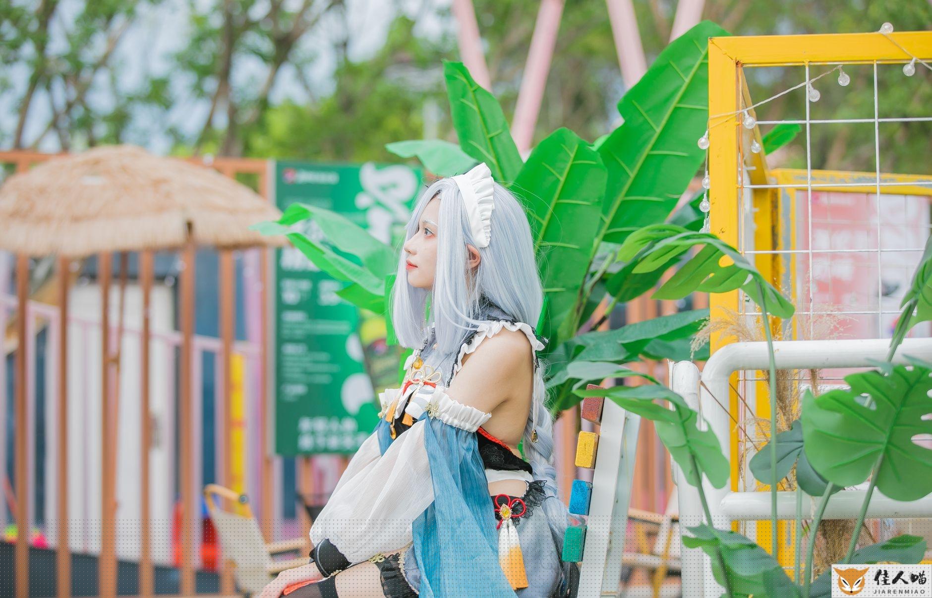 Cosplayer in colorful costume sitting outdoors with lush green leaves and a festive background.