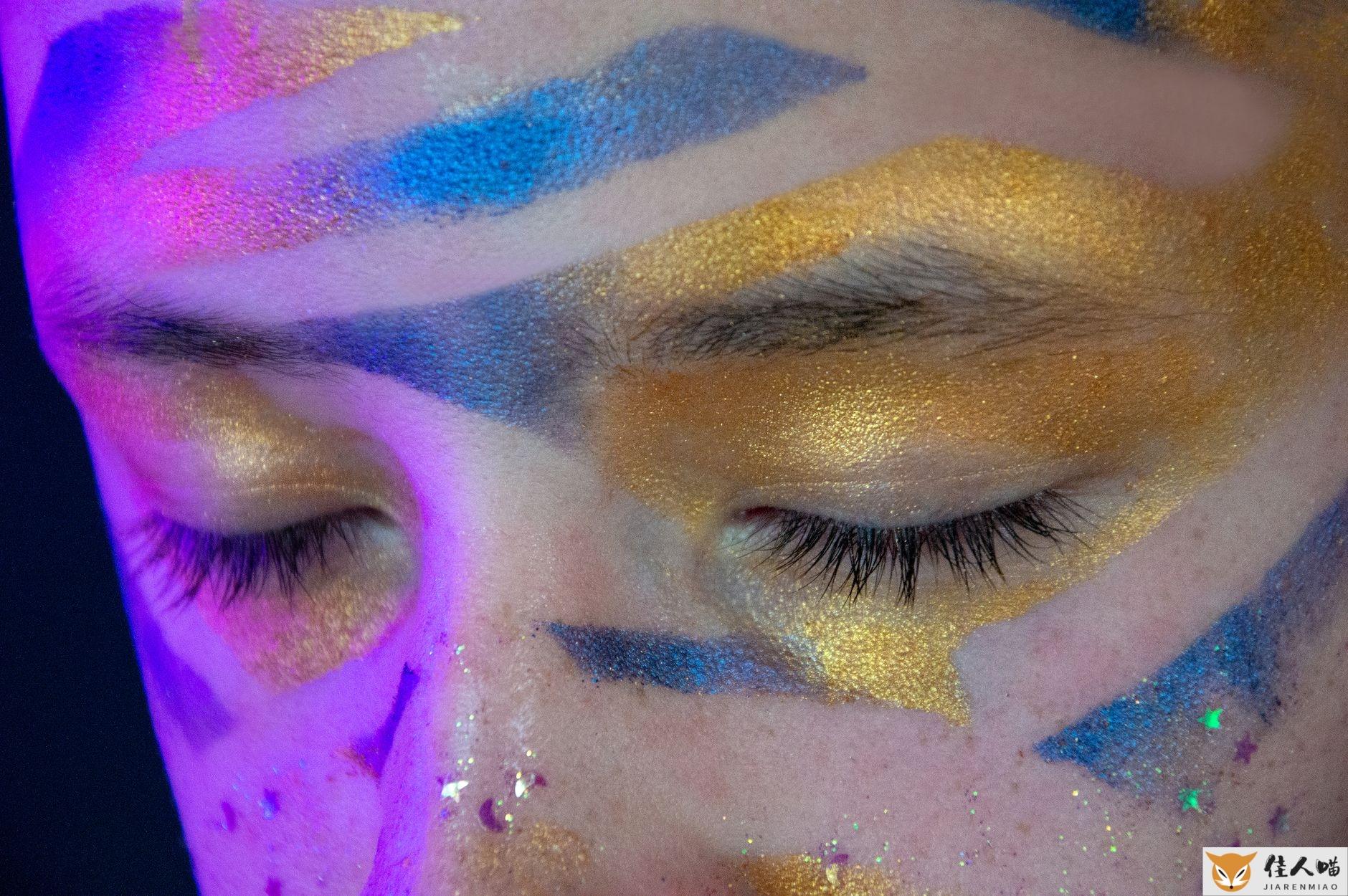 Closeup of artistic festival makeup with vibrant colors on closed eyes.